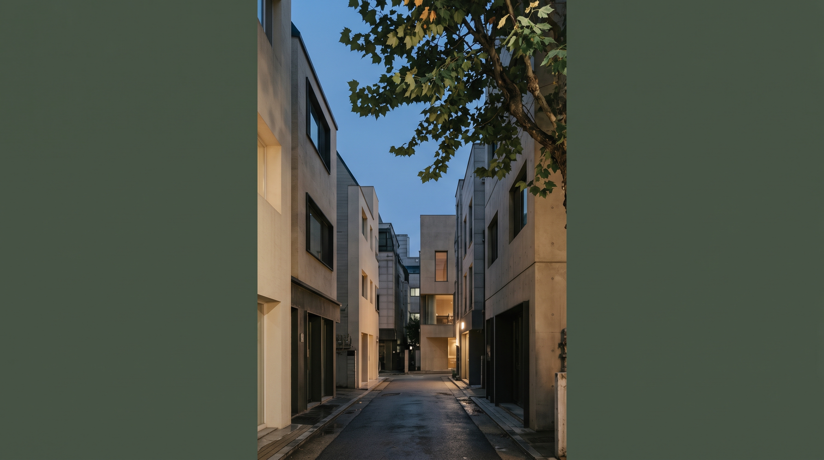 Vertical Seoul commercial alley at twilight blue hour, narrow street between mid-rise buildings with sage plane-tree leaves catching the last warm light