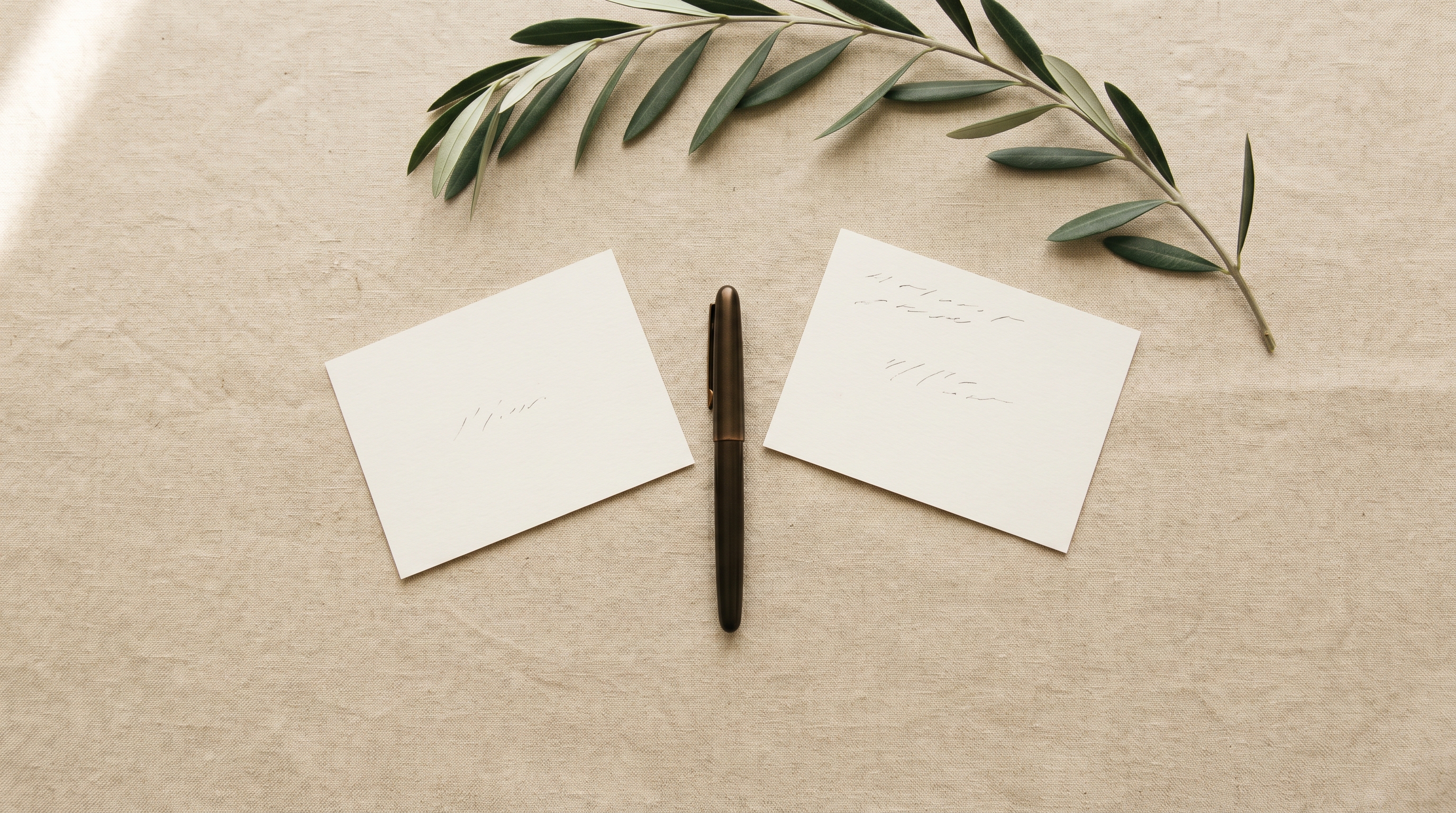 Two cream notecards angled toward each other with a bronze pen between them, visual metaphor for cross-language clinic communication